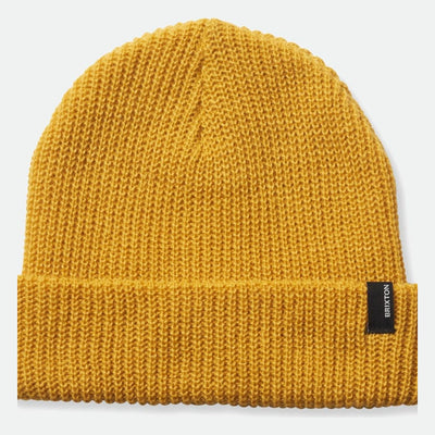 Close-up of Heist Mustard Beanie showing Gold knit fabric with tight ribbed texture throughout, black woven label at fold