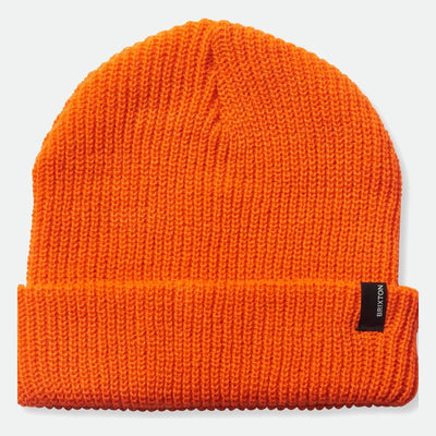 Close-up of Heist Mustard Beanie showing Bright orange knit beanie with ribbed knit texture and black woven label at cuff -