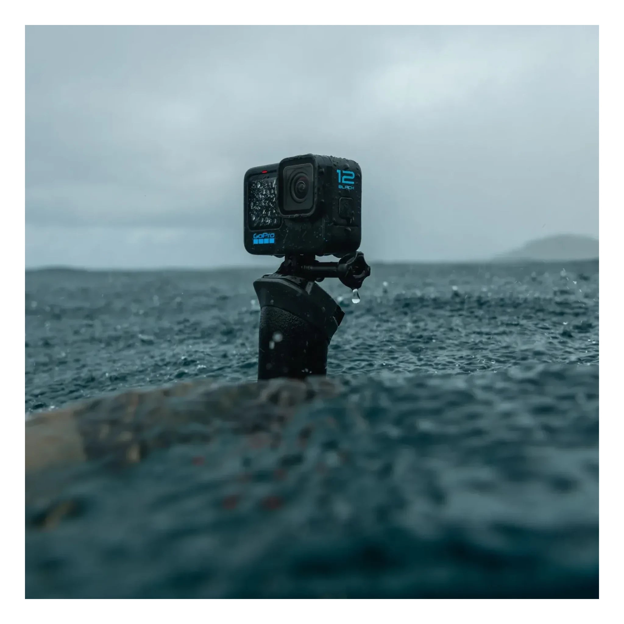 Person wearing Hero 12 Camera Black Camera, Action camera mounted on tripod in shallow ocean water with waves and cloudy sky
