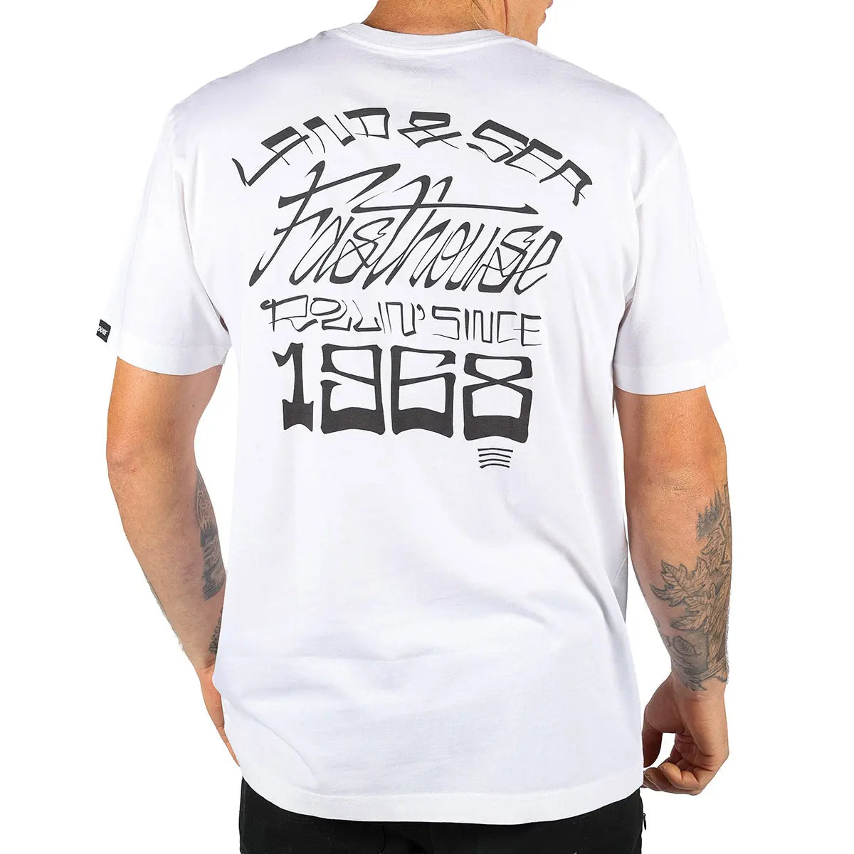 Person wearing Horizon Black Tee, Man wearing white tee standing indoors against plain background - Slowride Supply