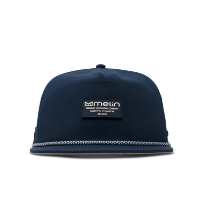 Close-up of Hydro Coronado Brick Black Hat showing Navy six-panel cap with white rope trim along bill and black woven label