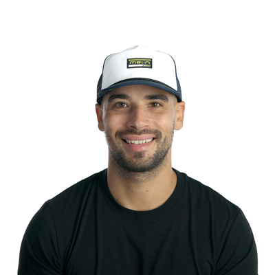 Person wearing Hydro Coronado MPH Black/iris/white Hat, Man wearing black t-shirt and white cap with navy brim against plain