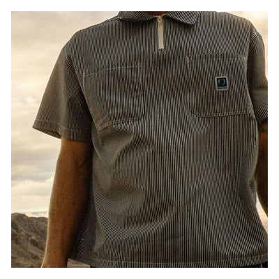Person wearing Journey LW SS Woven Navy/white Stripe S/S Woven S/S Woven, Desert landscape with cloudy sky and sandy terrain