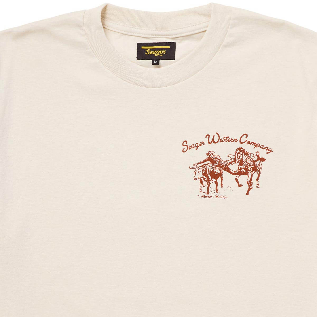 Close-up of Los Rios Vintage Black Tee showing Cream with rust-red bucking horse graphic and "Seager Western Company" script