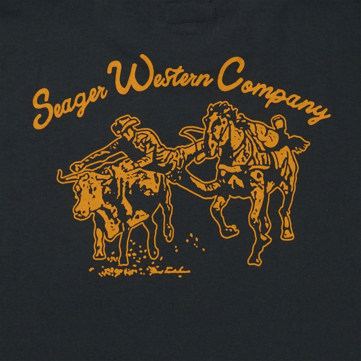 Close-up of Los Rios Vintage Black Tee showing Gold outline graphic showing two bucking horses with "Seager Western Company"