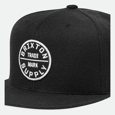 Oath III Snapback front view, Black with white circular trade mark emblem and horizontal dividing line on front panel,