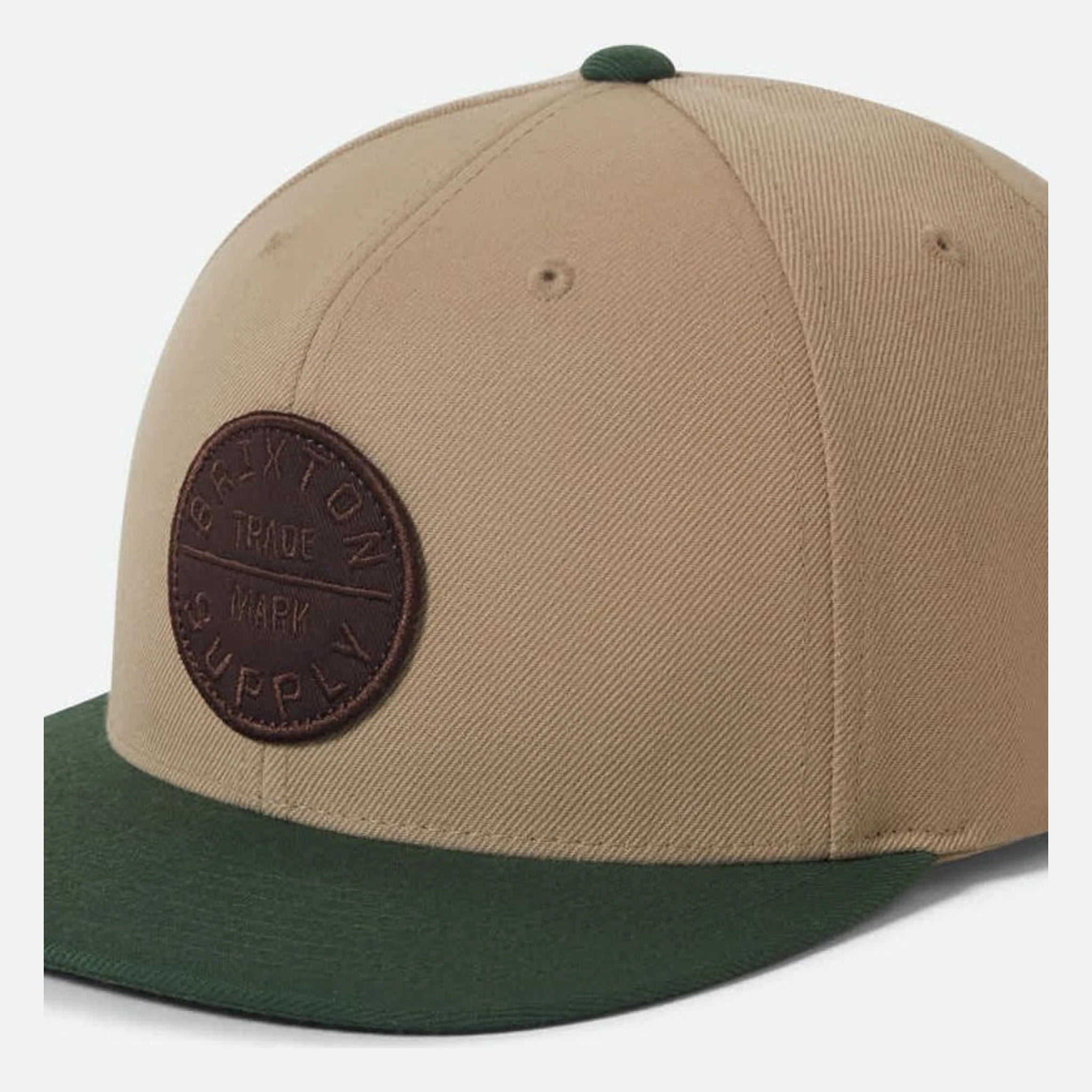 Close-up of Oath III Snapback Khaki/primal Green Hat showing Tan crown with dark brown circular leather patch embossed with