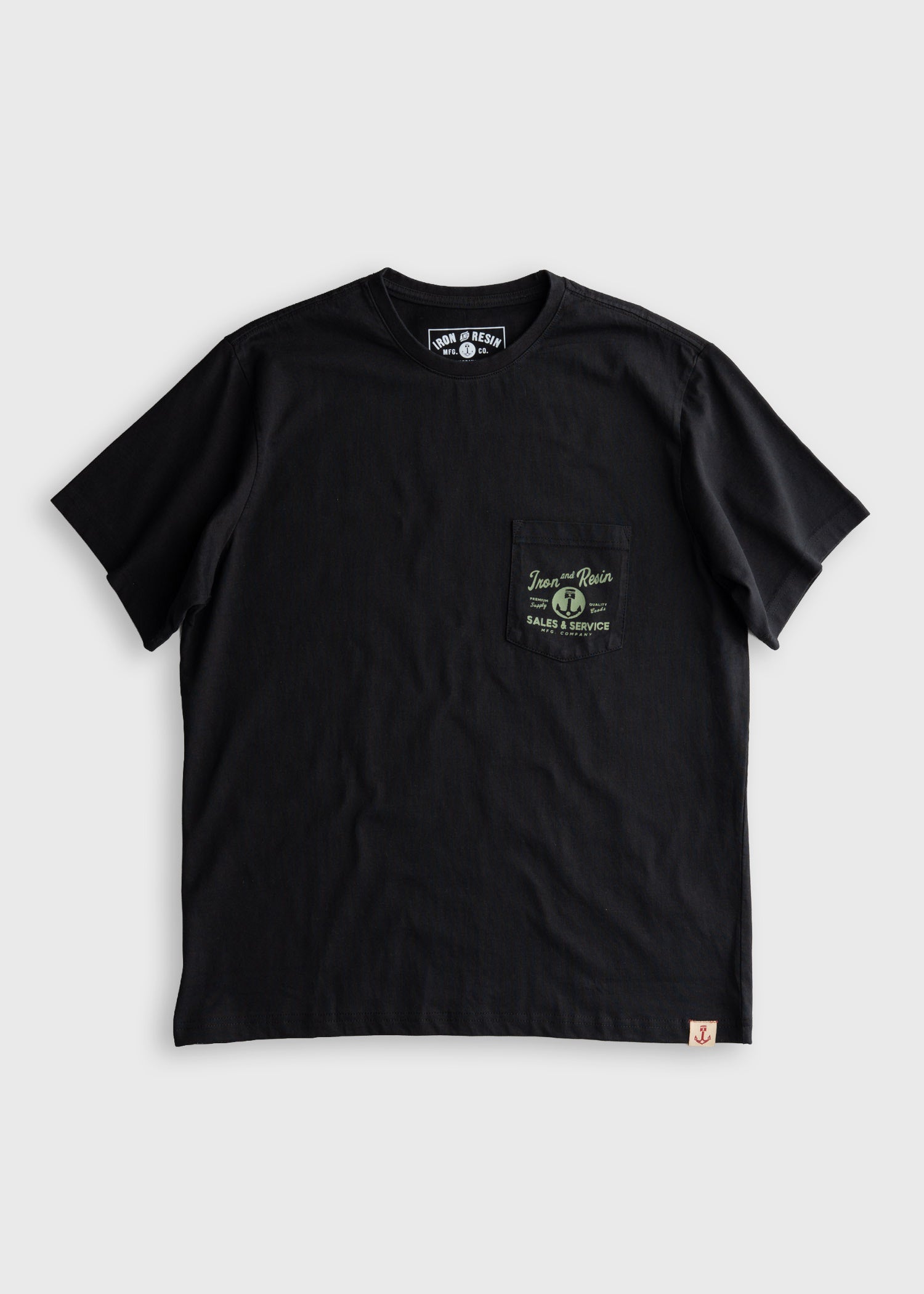 Close-up of Old Cowboy Pocket Black Tee showing Black cotton tee with chest pocket print featuring circular badge and "Sales