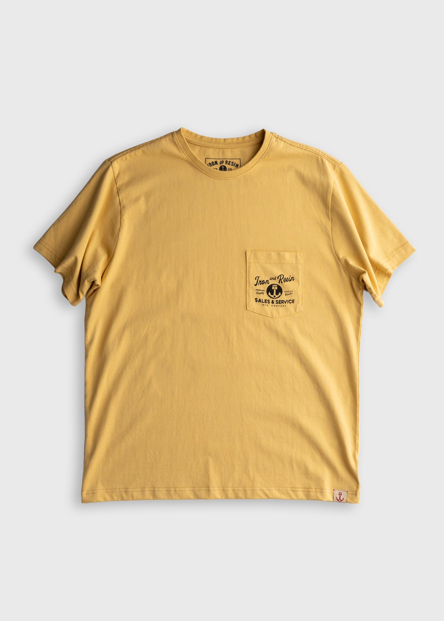 Close-up of Old Cowboy Pocket Black Tee showing Mustard yellow tee with chest pocket print reading "Iron and Resin Sales &