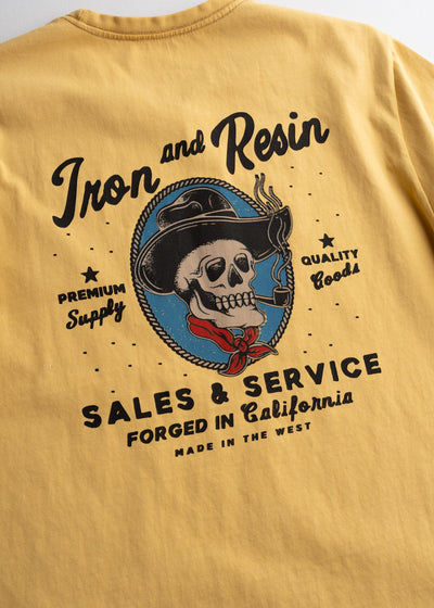 Close-up of Old Cowboy Pocket Black Tee showing Rope-bordered oval with skull in cowboy hat and red bandana, blue