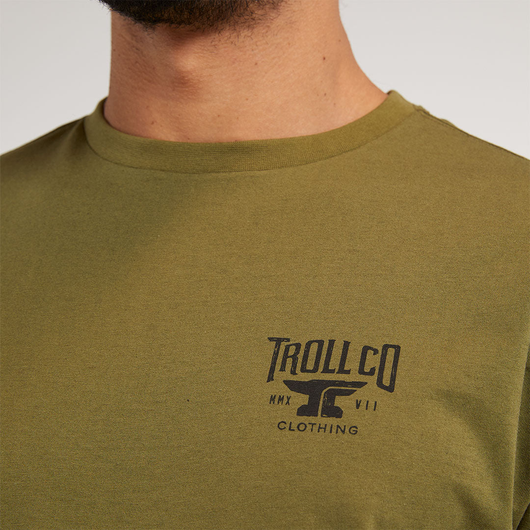 Person wearing Pay Me Military Tee, Worn against neutral studio background with soft lighting - Slowride Supply