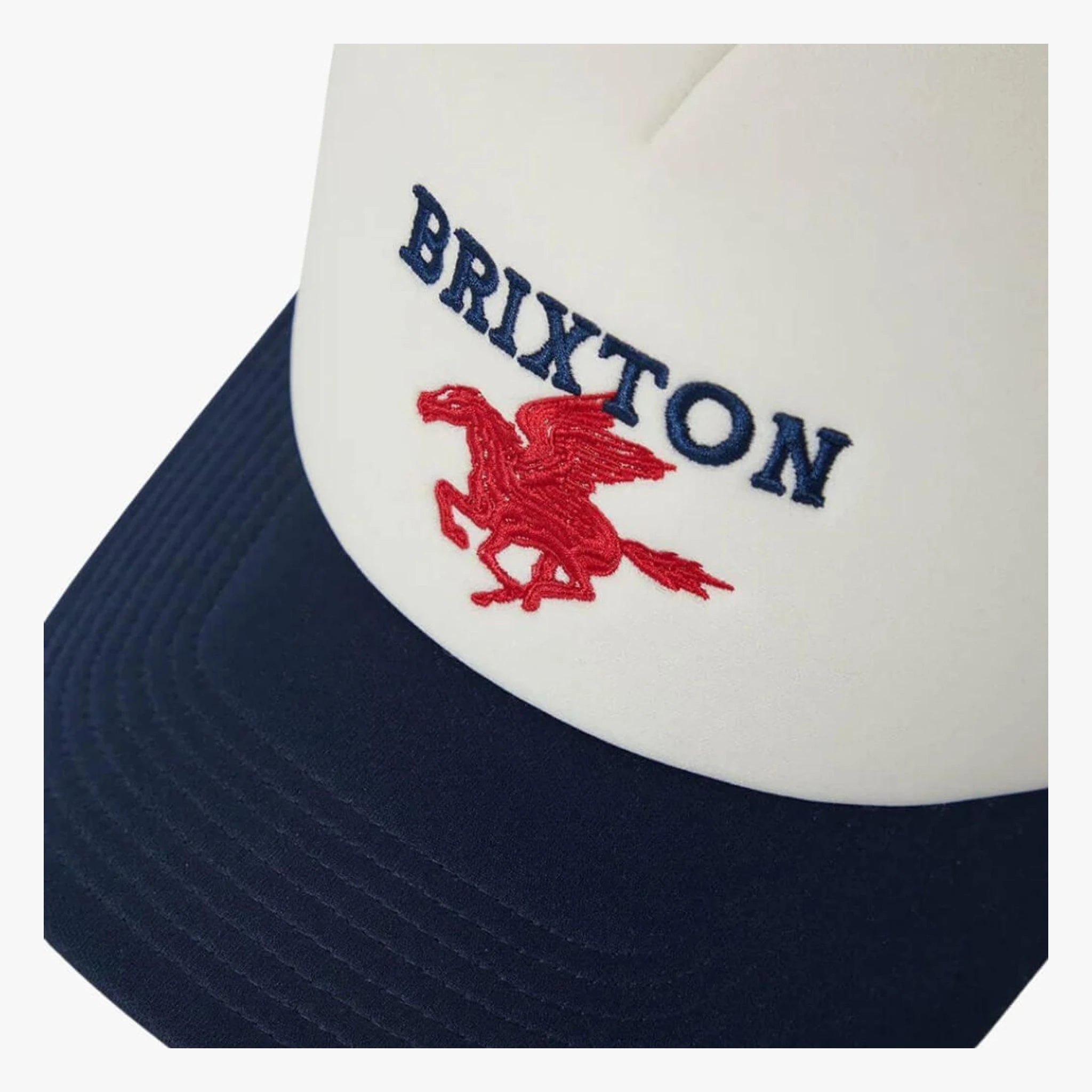 Close-up of Pegasus NP MP Trucker Apparel White Cap/Navy Apparel showing Embroidered navy text and red rearing horse graphic