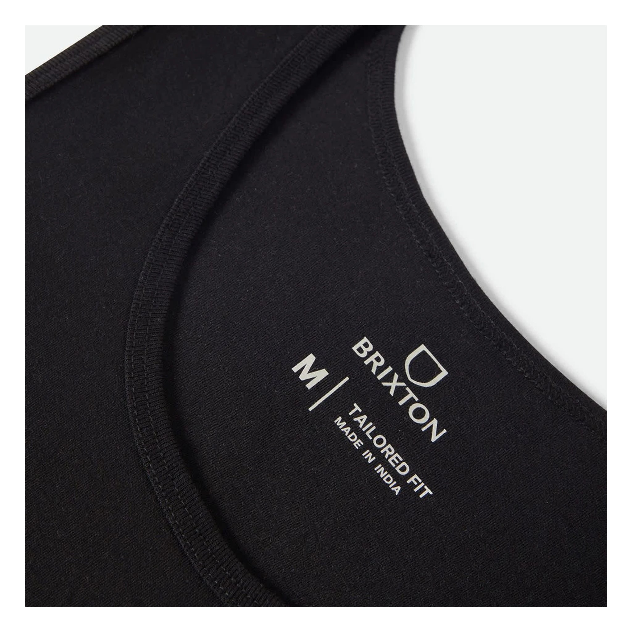 Close-up of Pinnacle Tank Top Apparel Black Apparel showing White text and logo on black fabric, reading "BRIXTON M/I