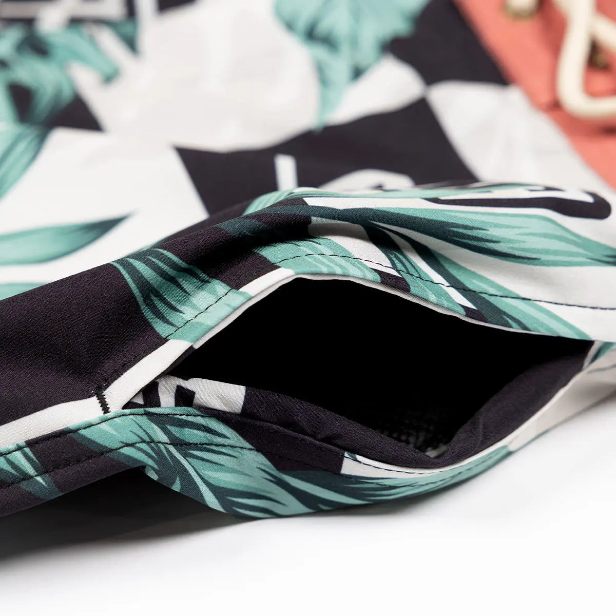 Close-up of Poolside 19" Boardshort Apparel Black/Off White Apparel showing Teal leaf graphic print with black and white