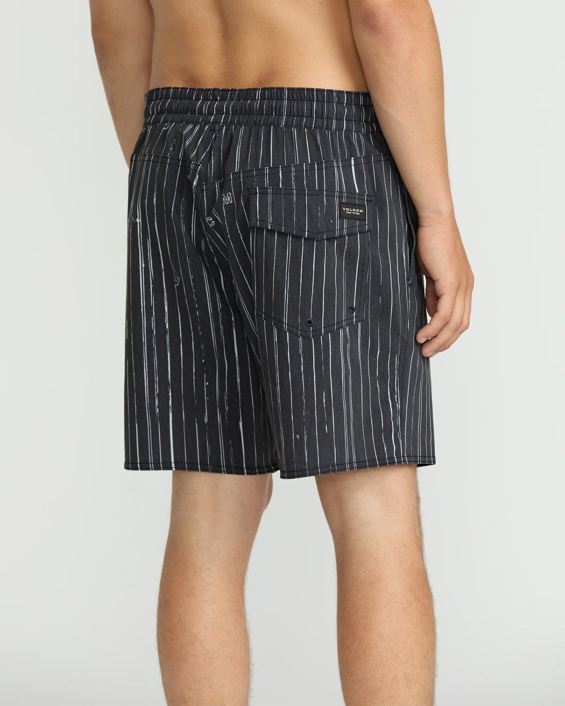 Person wearing Psyche Cotton Trunk 17" Apparel Black Apparel, Rear view of black pinstriped swim trunk worn by shirtless man