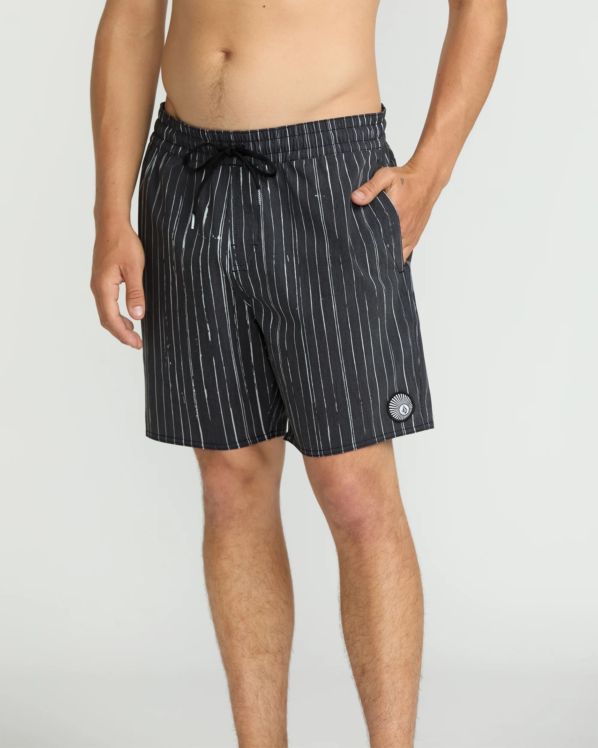Person wearing Psyche Cotton Trunk 17" Apparel Black Apparel, Man wearing black pinstriped shorts against neutral studio