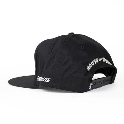 Close-up of Runner Hat Apparel Black Apparel showing Black cotton twill snapback with white embroidered text on front and