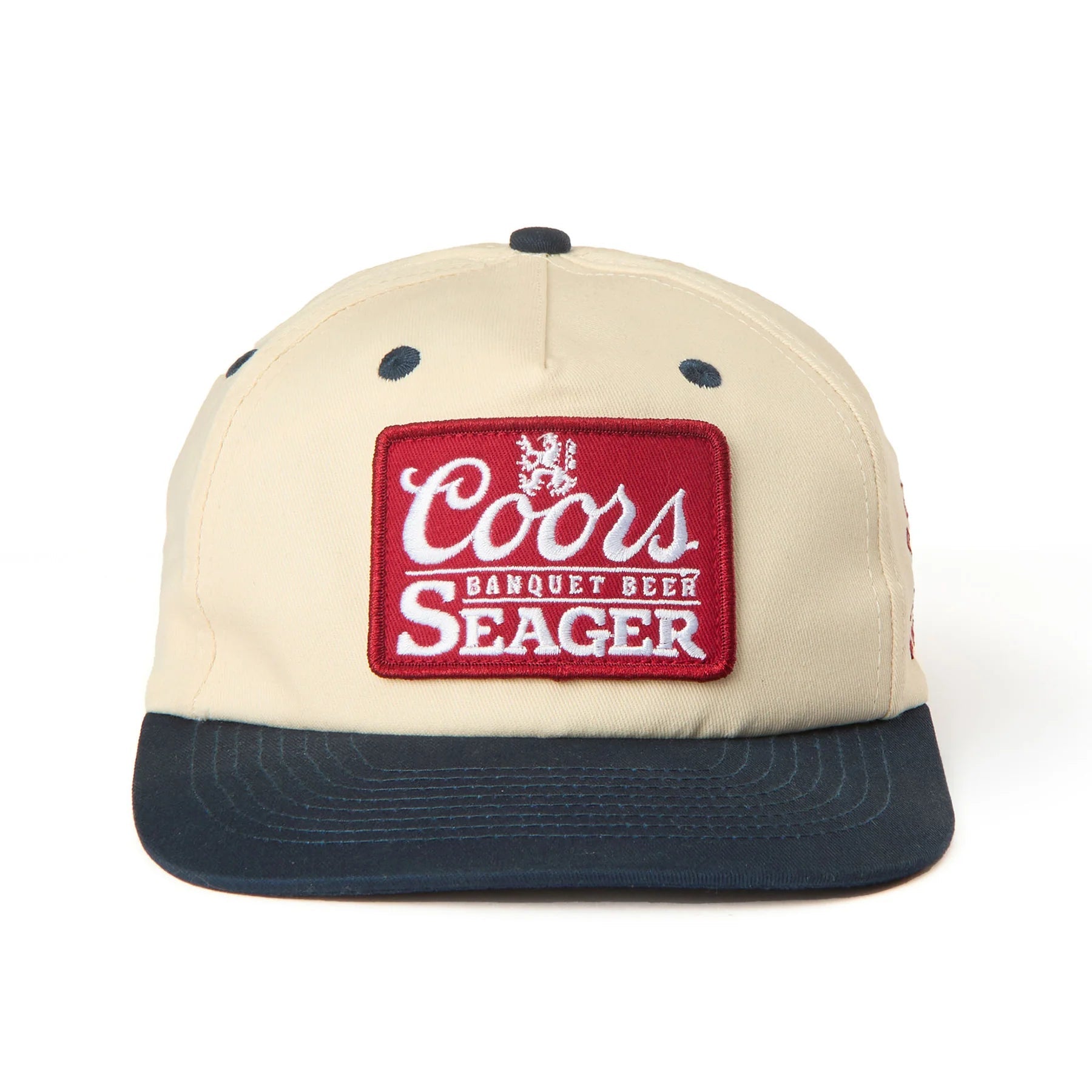 X Coors Banquet P.o.p. Snapback front view, Cream crown with navy blue visor and embroidered red patch featuring white
