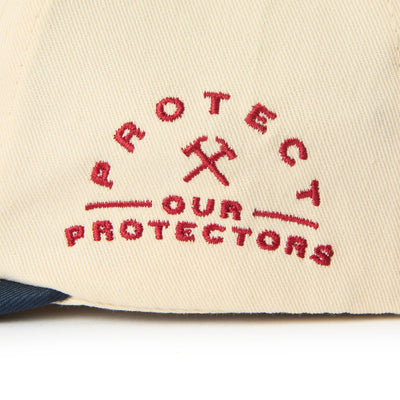 Care label on X Coors Banquet P.o.p. Snapback Cream/navy-cream/navy Hat showing Red embroidered text reading "Protect Your