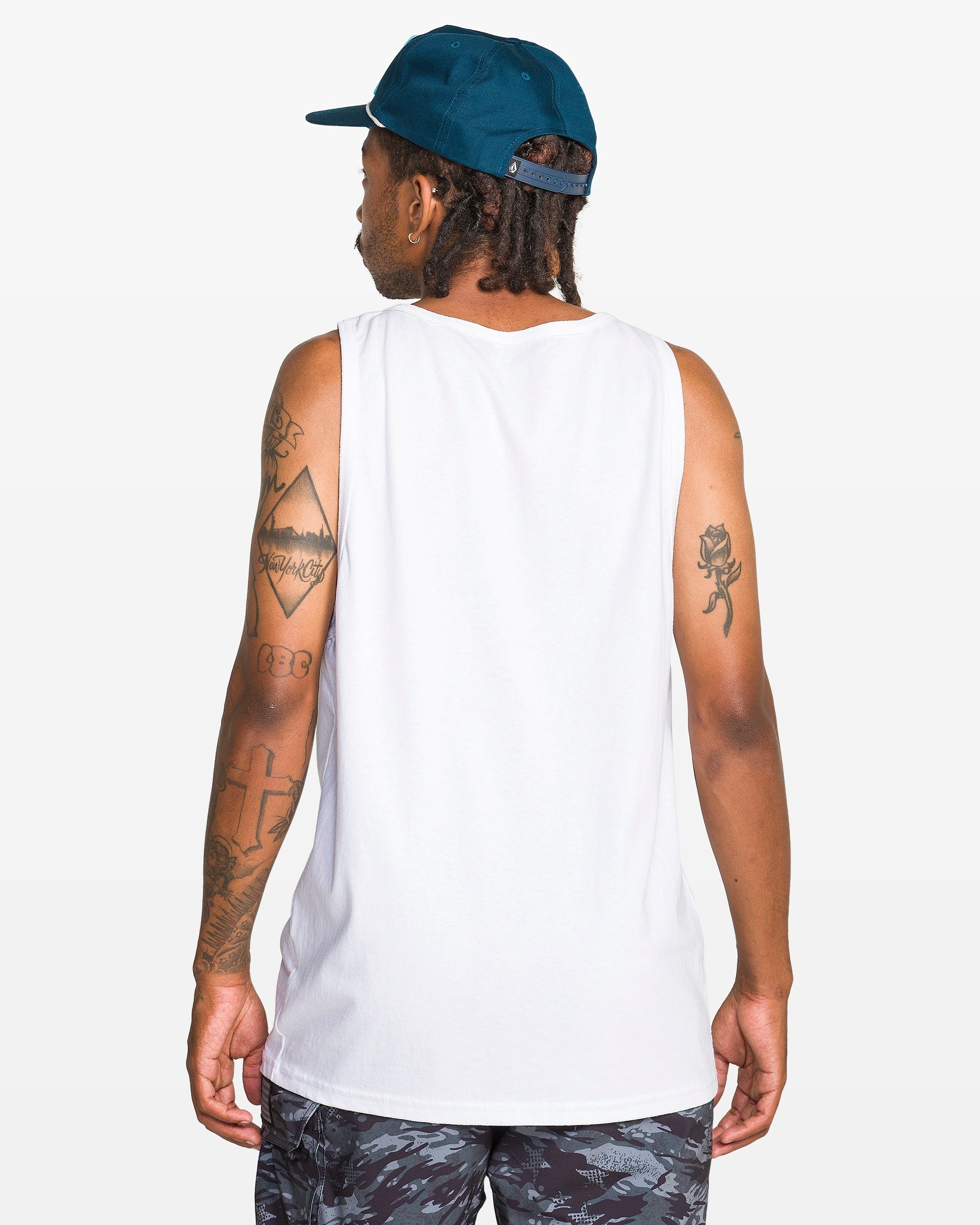 Person wearing Serve Stoked Tank Apparel White Apparel, White sleeveless tank against plain studio backdrop - Slowride Supply