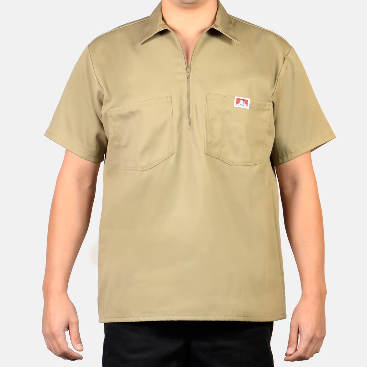 Person wearing Short Sleeve Solid Half Zip S/S Woven Black S/S Woven, Tan work shirt displayed on plain white background -