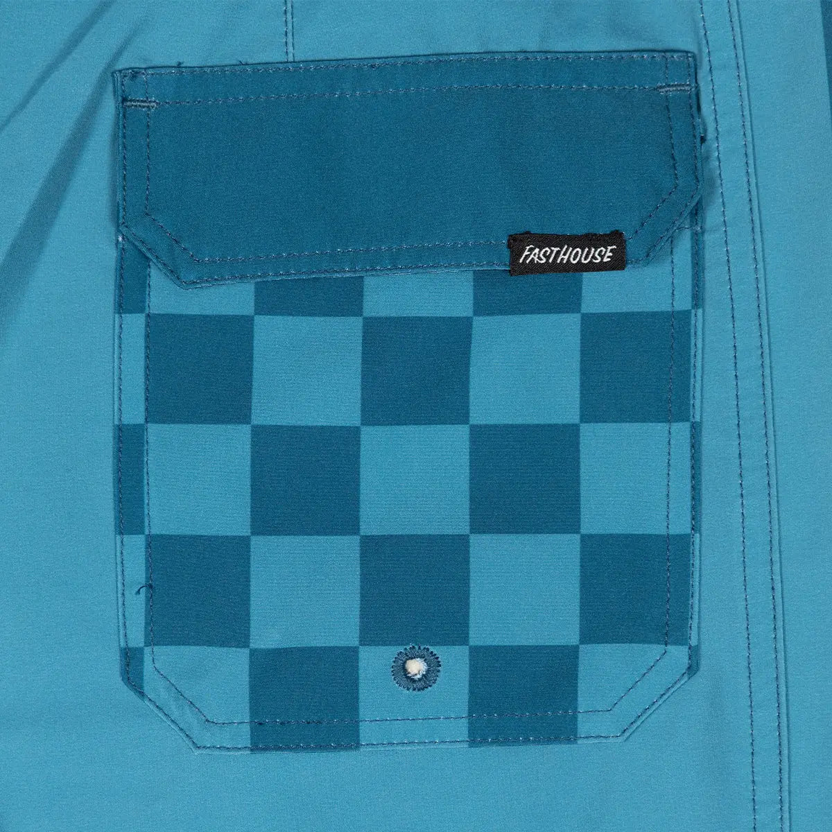 Close-up of Skeg 19" Boardshort Apparel Indigo Apparel showing Chest pocket with teal and navy checkerboard pattern and