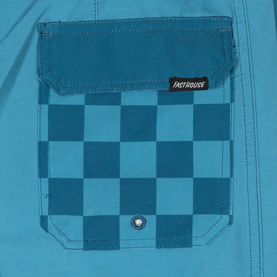 Close-up of Skeg 19" Boardshort Apparel Indigo Apparel showing Chest pocket with teal and navy checkerboard pattern and