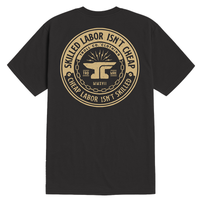 Close-up of Slic Black Tee showing Tan circular seal on black with anvil centerpiece, chain border, and text reading