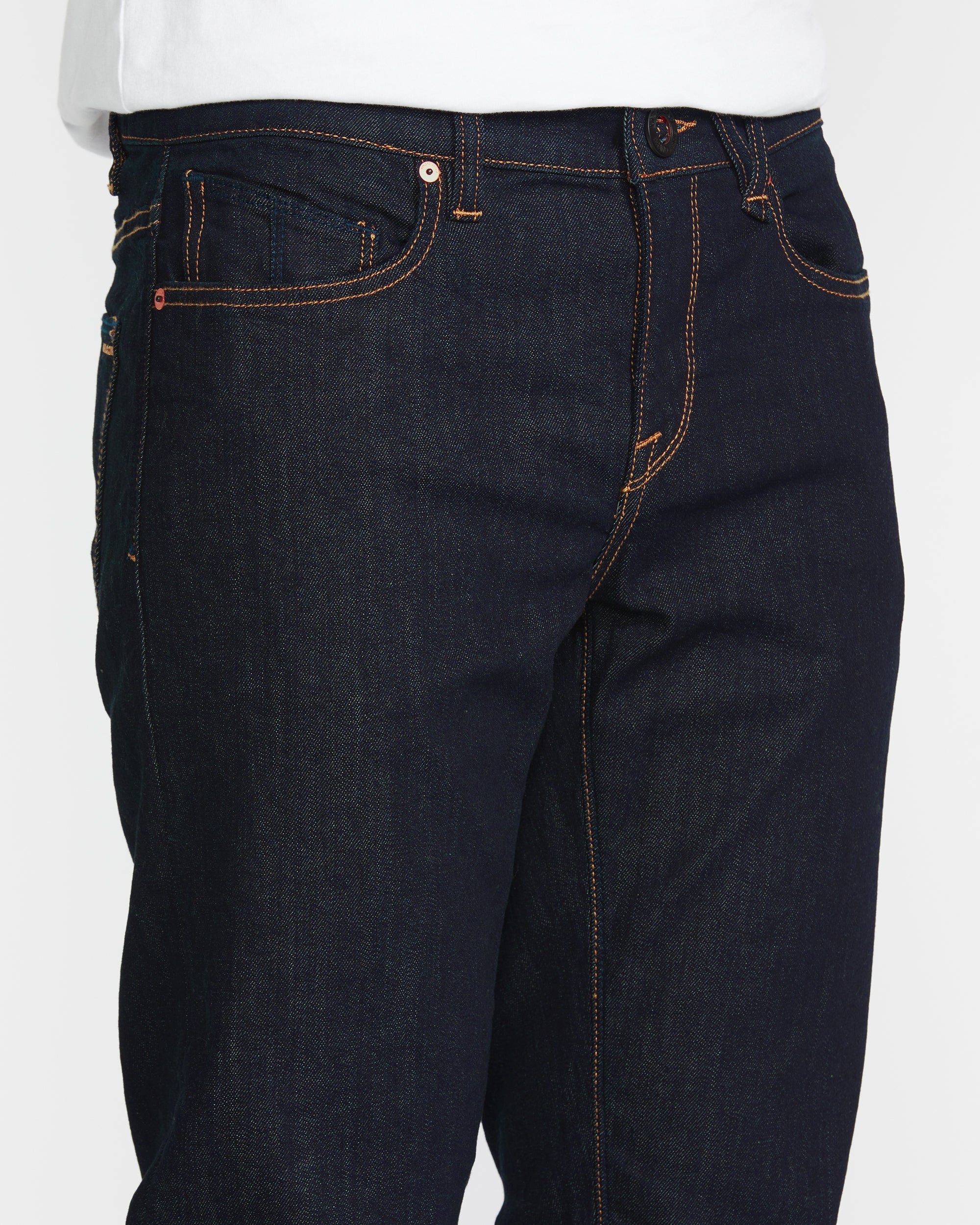 Close-up of Solver Denim Pants Vintage Blue Pants showing Copper and tan contrast stitching on raw indigo denim with visible