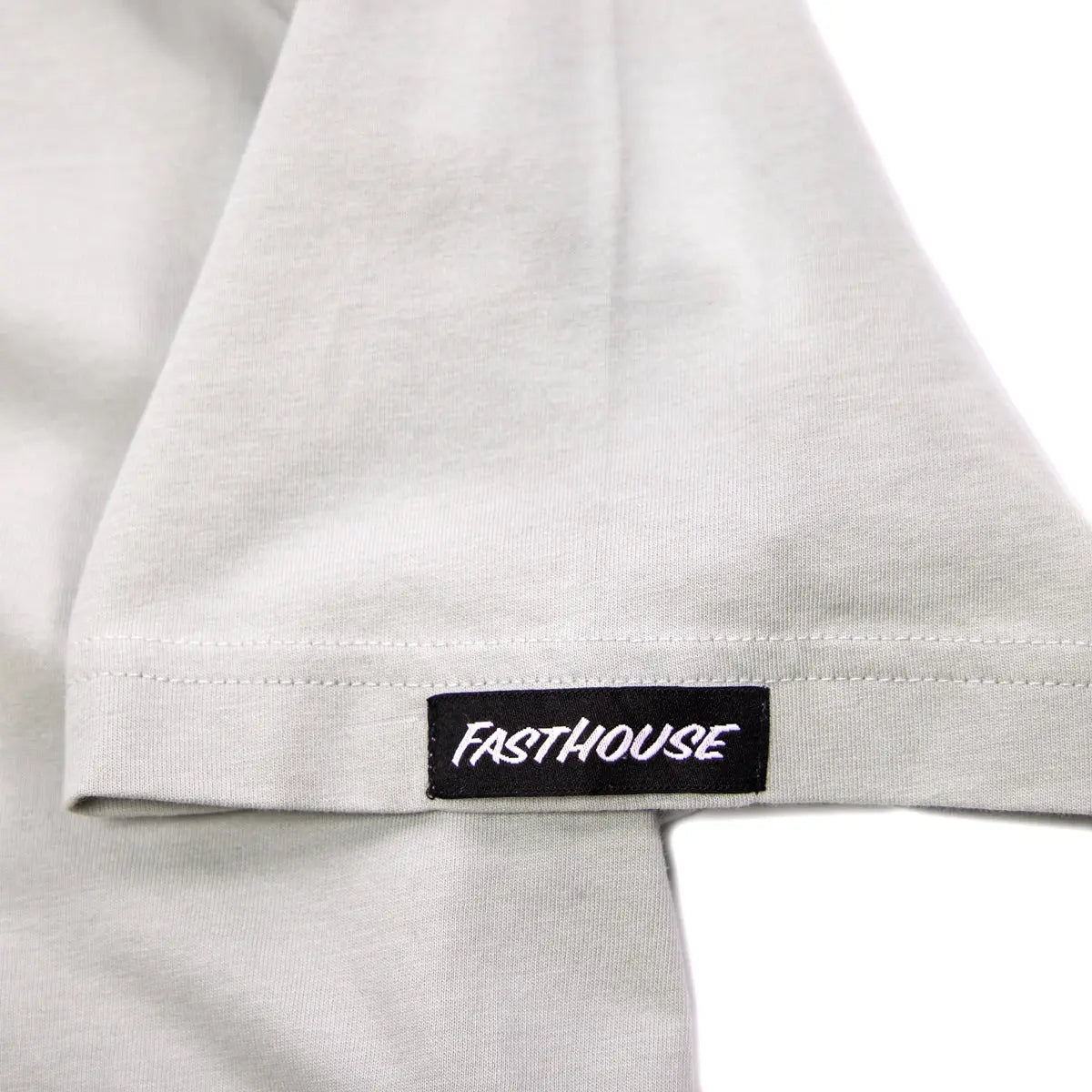 Close-up of Spanner Mirage Gray Tee showing Black woven label with white italic text on white cotton hem - Slowride Supply