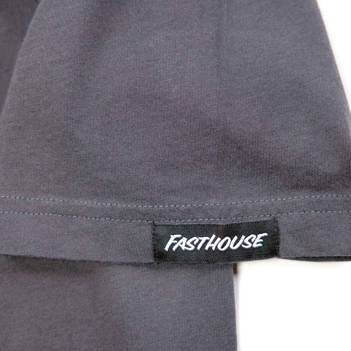 Close-up of Spanner Mirage Gray Tee showing Black woven label with white text on gray ribbed hem - Slowride Supply