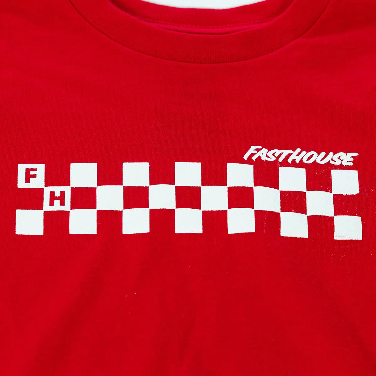 Close-up of Toddler Riff Tee Kids Red Kids Tee showing White checkered flag graphic with red and white letters on red fabric