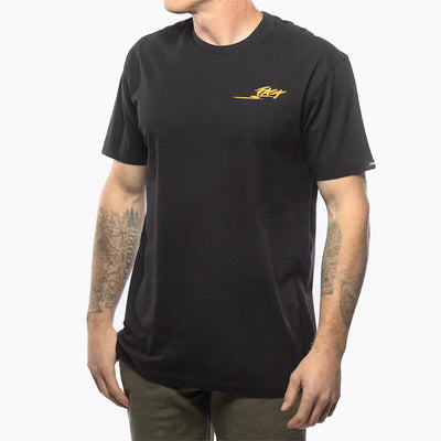 Person wearing Tomahawk Natural Tee, Man wearing black tee against white studio background - Slowride Supply