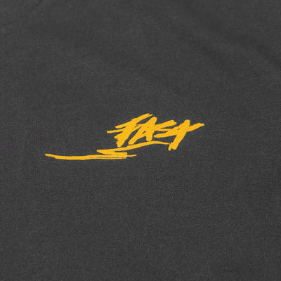 Close-up of Tomahawk Natural Tee showing Gold embroidered script logo on charcoal cotton jersey with directional underline
