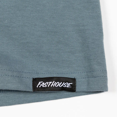 Close-up of Trust Tank Apparel Indigo Apparel showing Black woven label with white script text on ribbed hem edge - Slowride