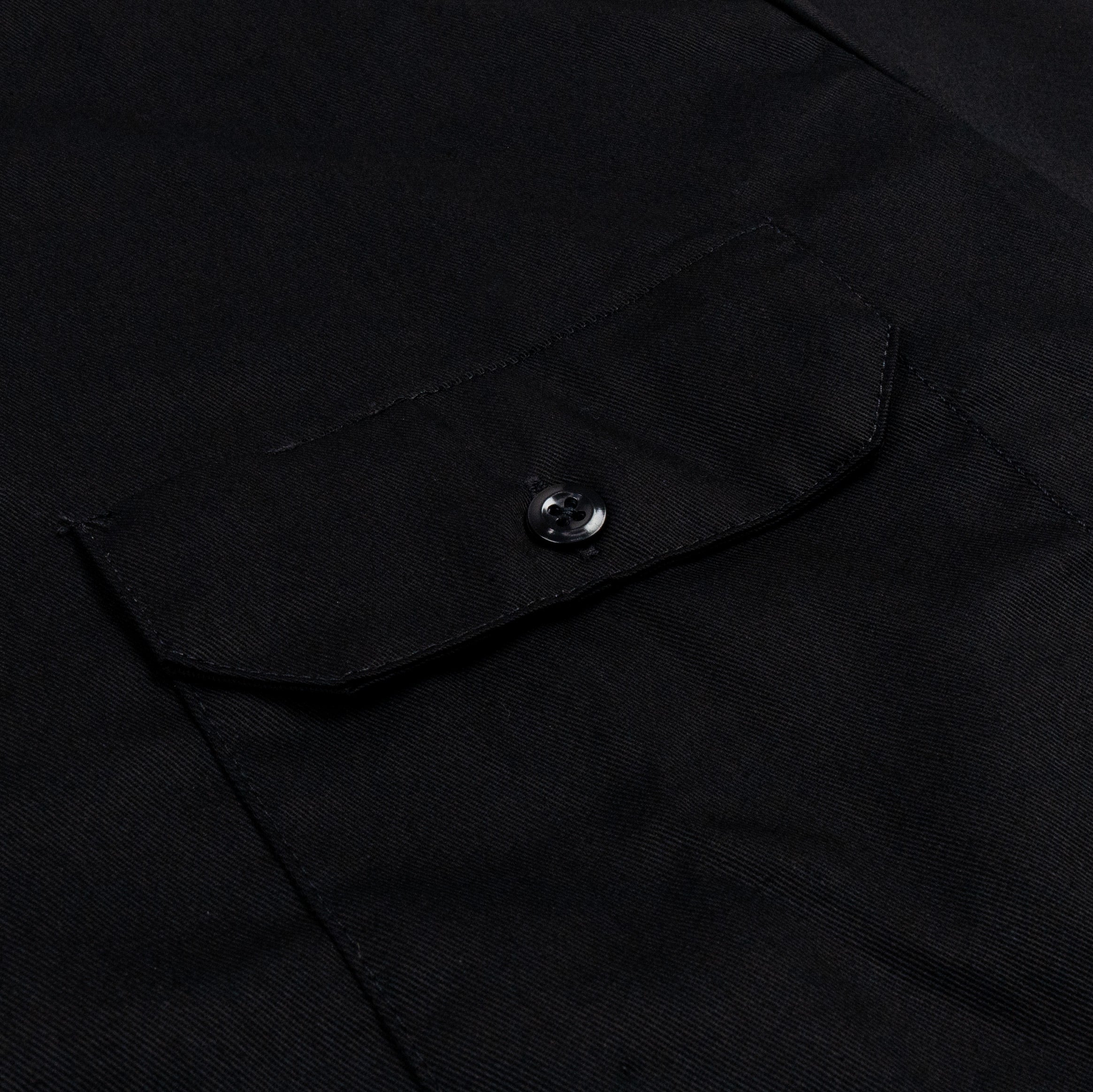 Close-up of Woven Twill Shirt S/S Woven Black S/S Woven showing Chest pocket with metal snap button closure and angled flap
