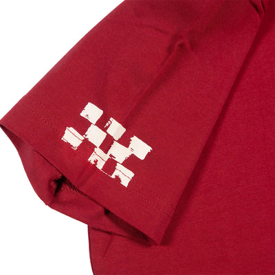 Close-up of Youth Alkyd Tee Cardinal Kids Kids Tee showing White distressed block print on cardinal red sleeve, with uneven
