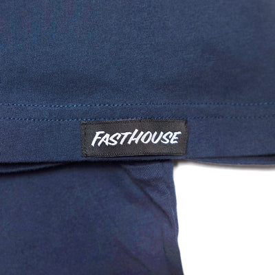 Close-up of Youth Demolition Tee Kids Navy Kids Tee showing Black woven label with white italic text on navy seamed hem -