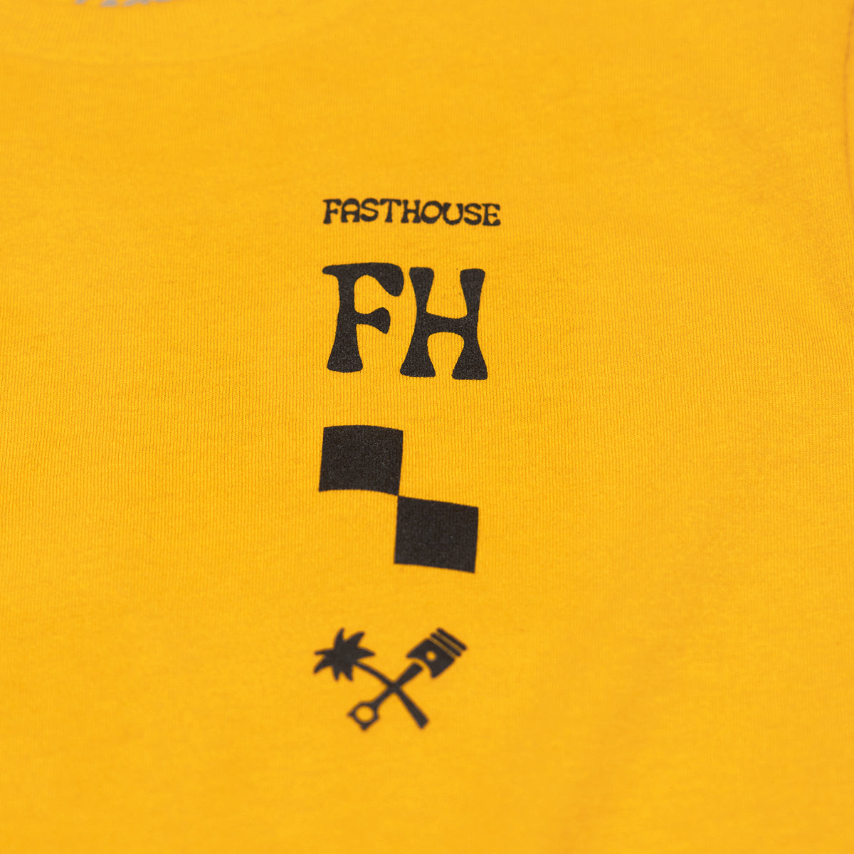 Close-up of Youth Gold Mine Tee Kids Vintage Gold Kids Tee showing Vintage gold with black "Fasthouse" text, large "FH"